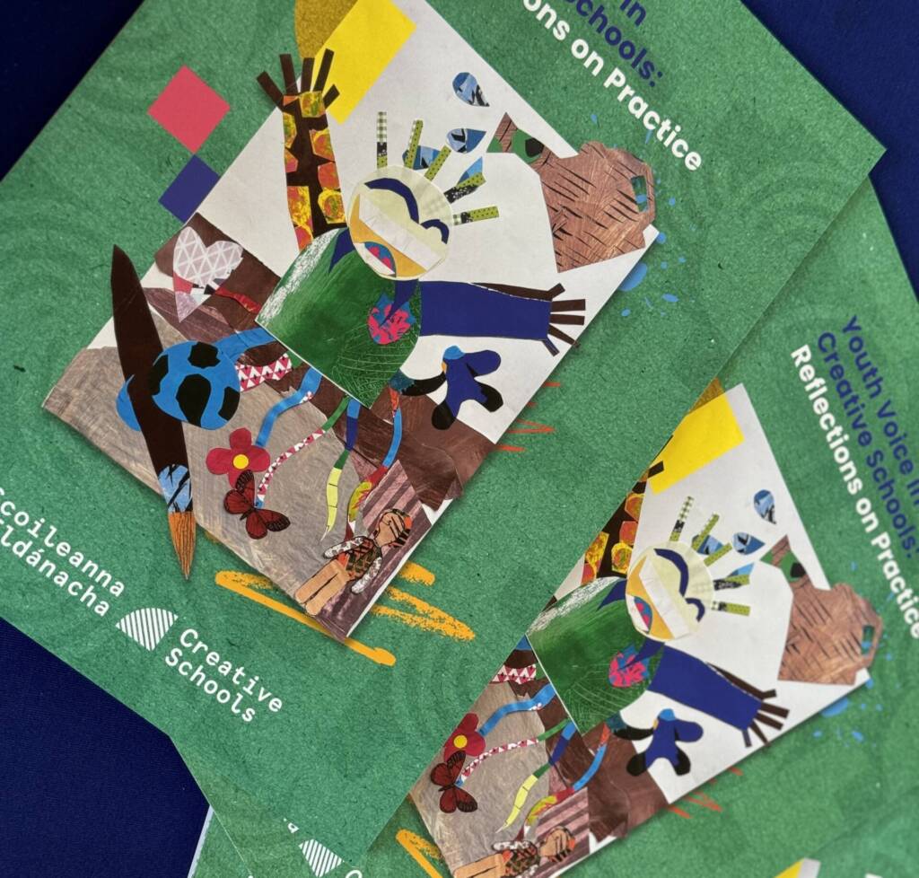 Three vibrant Creative Schools Reflections on Practice pamphlets sit on a blue table. The pamphlet shows a child playing with a ball, the child is composed of a collage of different coloured papers